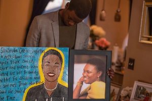 Chris Singleton holds a photo and a poem of his mother, Sharonda.