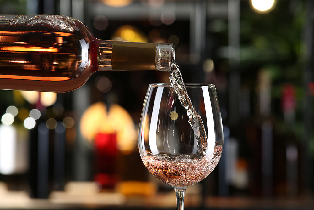 Rose wine being poured from a bottle.