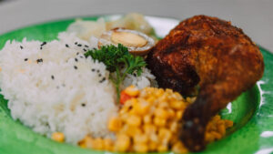 Healthier Eating: Chicken, rice and corn dinner on a decorative green plate.