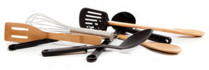 Wooden, plastic and metal kitchen implements for cooking and serving.
