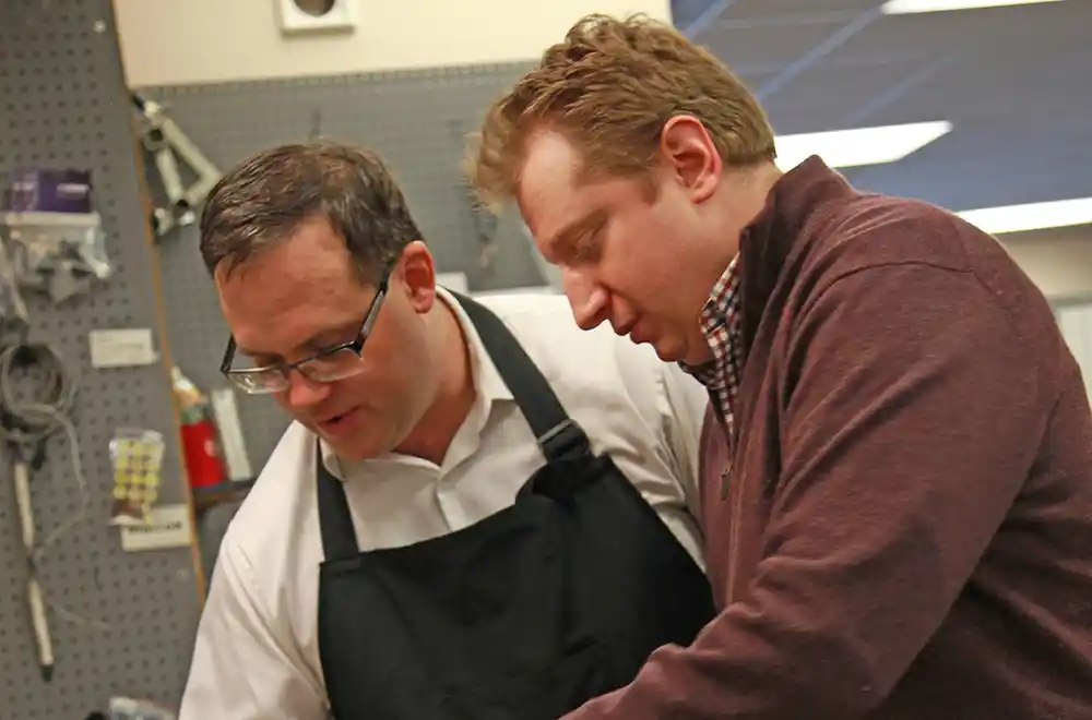 Photo of Chris Bluemel with CSO concertmaster Yuriy Bekker discussing bow rehair technique