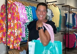 Dawn Drucker holding a Simply Country Chic Boutique shopping tote in her Summerville, SC boutique.