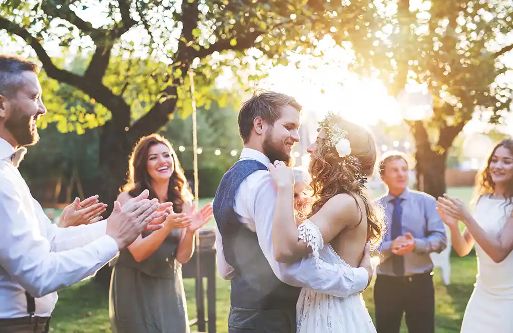 A couple married in a backyard wedding surrounded by family.