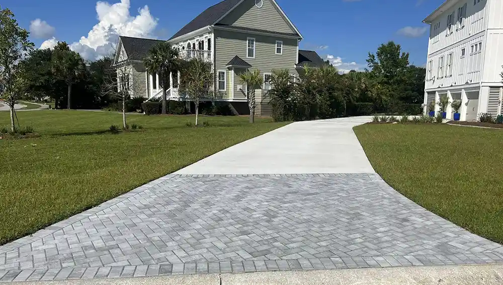 Morales Pavers: A new concrete driveway with a Herringbone Paver Entrance replaces an old cracked concrete driveway.