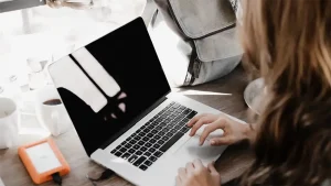 A woman blogger powering up her laptop. Photo credit Andrew Neel on Unsplash.com.