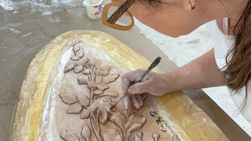 Photo of Carolyne Chardac making a flower sculpture with clay