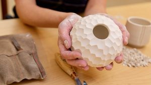 Photo of a woman holding a clay vase