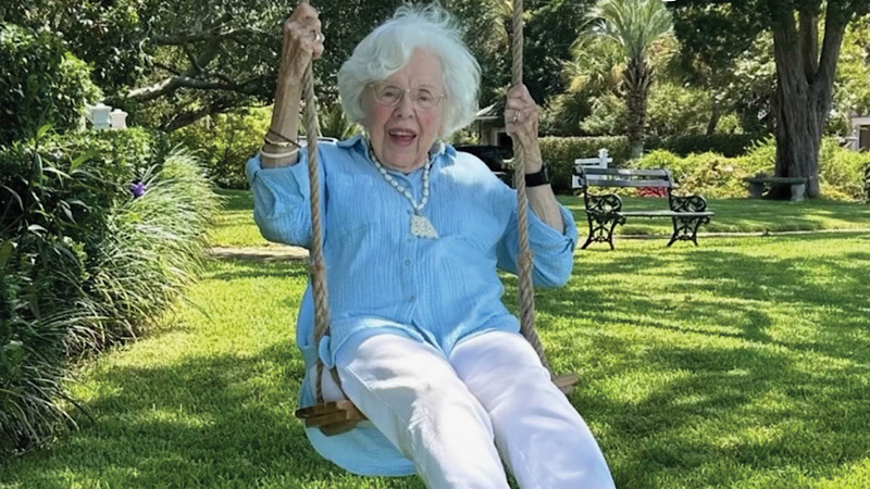 Photo of Ann Edwards on a swing