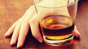 Image of a hand holding a whiskey glass