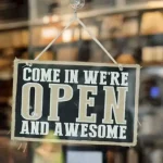 Sign on business door: Come in We're Open and Awesome