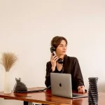 A woman business owner at her desk on the phone.