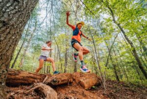 This image displays two women hiking in a forest