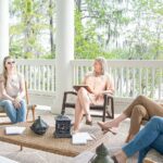 This image displays five women sitting in a semi circle and seem to be discussing something