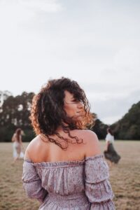 The image displays a back-shot of Dr. Kate Glebocki owner of Ivy in an open field