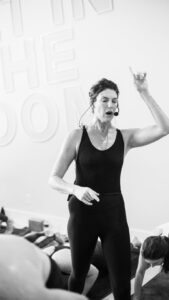 This image displays wellness instructor Sarah Frick in the midst of directing a class