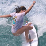 This image displays an cation shot of 17 year old surfer Skye Dominguez surfing