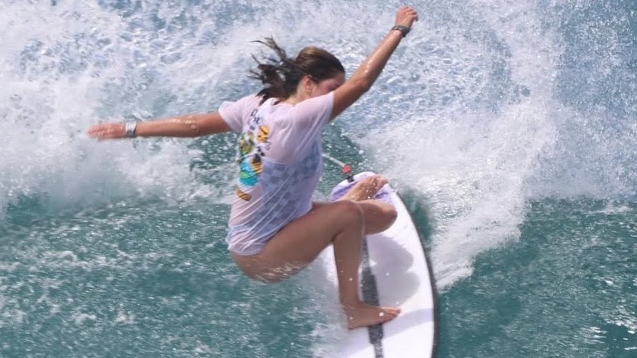 This image displays an cation shot of 17 year old surfer Skye Dominguez surfing